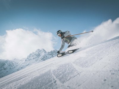 A Ladurns, c’è l’hotel perfetto per le vacanze invernali Sciatore che scende velocemente una pista innevata con cielo limpido