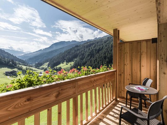Hotel in Pflerschtal: Aktivhotel Panorama Balcony with table and chairs overlooking green mountains and blue sky