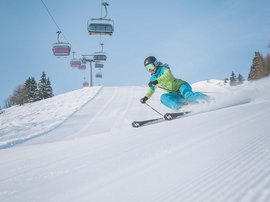 Vacanze invernali in Val di Fleres Sciatore con giacca verde su pista innevata ben preparata con cielo azzurro