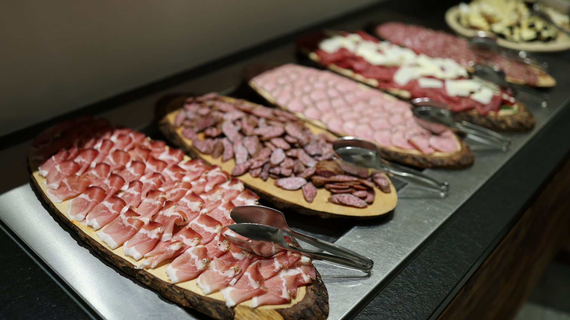 Culinary delights from Pflersch: Hotel Panorama Wooden board with cold cuts, pickles, tomatoes and cheese on outdoor rustic table