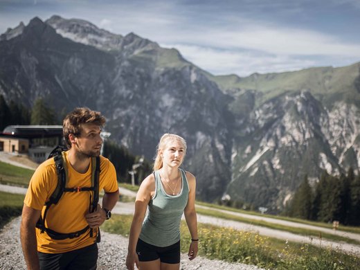 Hotel in Pflerschtal: Aktivhotel Panorama Two hikers on a mountain trail with steep rocky mountains in the background