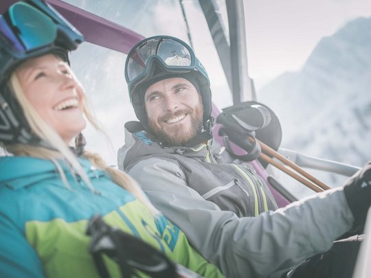 Vacanze invernali in Val di Fleres Due sciatori con abbigliamento da sci e casco su una seggiovia sulla neve
