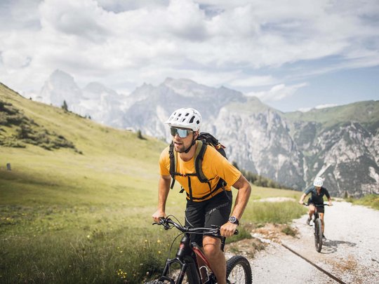Pflerschtal: Unterkünfte furs Biken Zwei Radfahrer mit Helm fahren auf Bergweg in grüner Landschaft