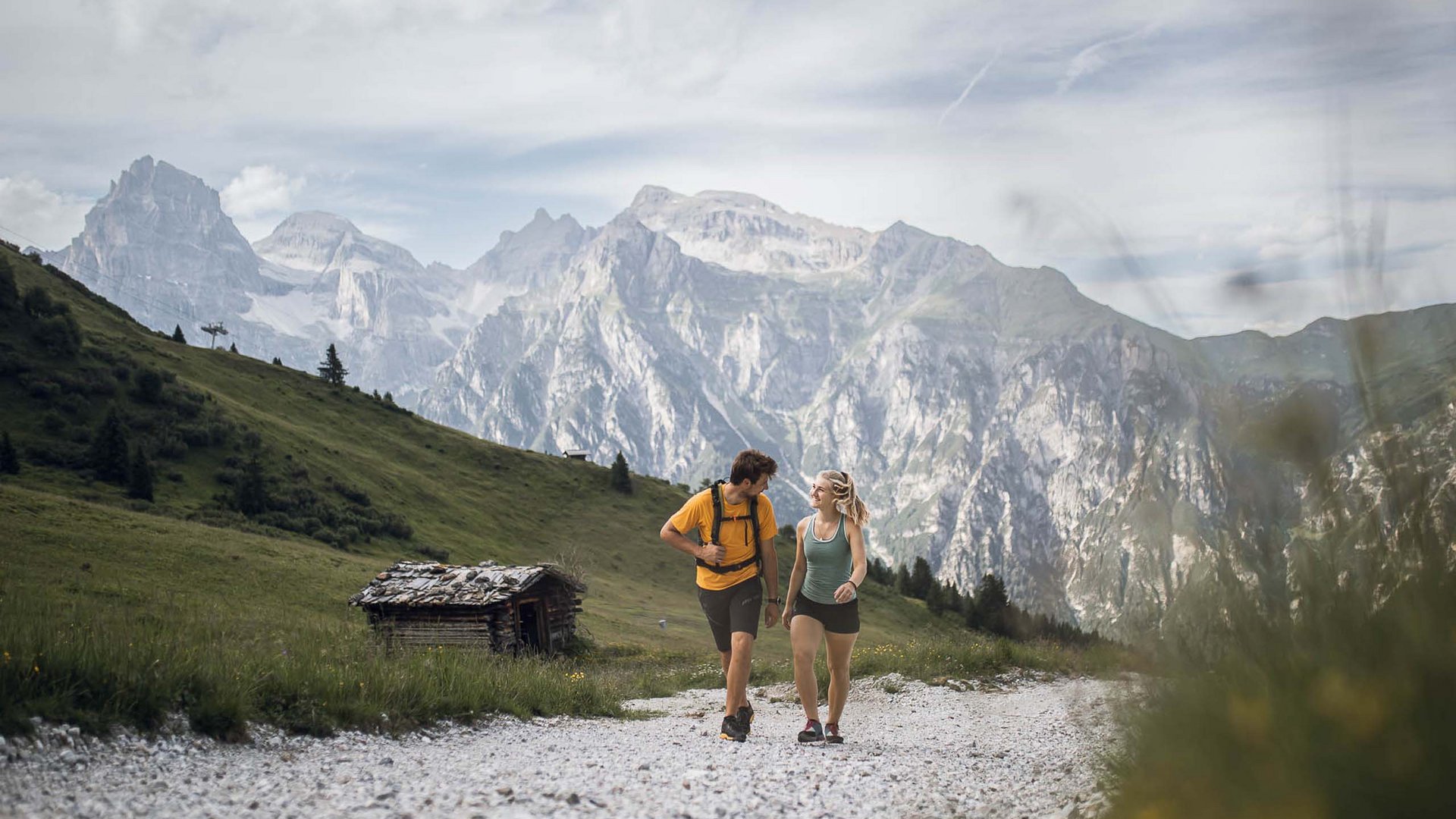 Aktivhotel in Südtirol: Sommererlebnisse Zwei Wanderer unterwegs auf Bergweg mit Alpen im Hintergrund