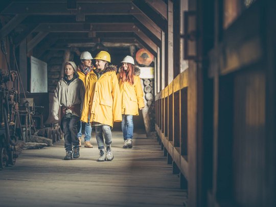 Dall’hotel a Colle Isarco a 3 stelle verso l’avventura Gruppo di persone con caschi e giacche gialle in una struttura di legno