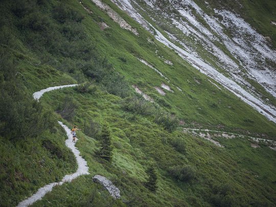 Aktivhotel Panorama: Wandern Wanderer auf schmalem Pfad entlang grüner Berghänge