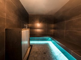 Wellness in der Unterkunft im Pflerschtal Moderner Dampfraum mit dunklen Fliesen und blauem Beleuchtungsakzent