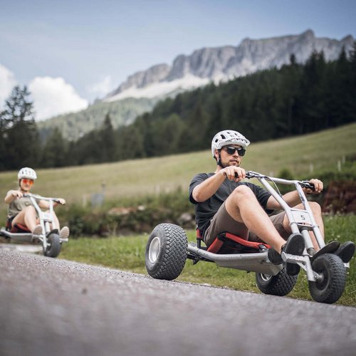I nostri alloggi a Colle Isarco: una base per mille avventure Due persone guidano tricicli a pedali su una strada di montagna