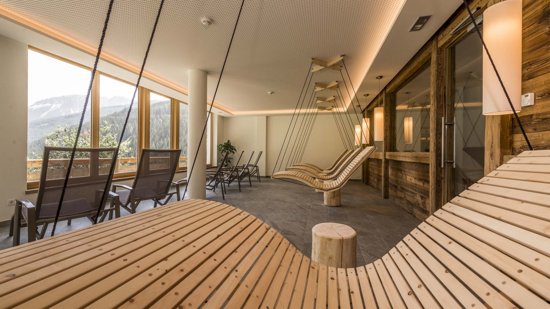 Modern relaxation area with wooden swings and mountain view