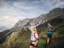 Aktivhotel Panorama: Wandern Zwei Wanderer auf Bergpfad mit Bergen und Wald im Hintergrund