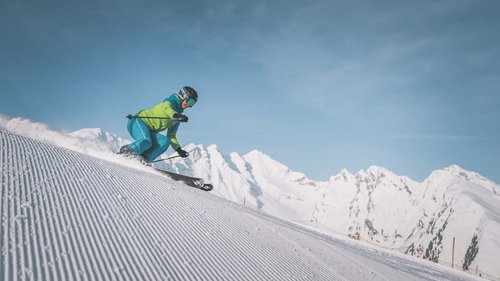 Ski touring in Pflerschtal Skier on groomed slope with snowy mountains in the background