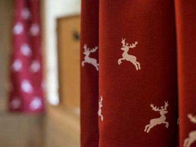 Hotel in Pflerschtal: rooms and offers Red curtains with white reindeer patterns in a room