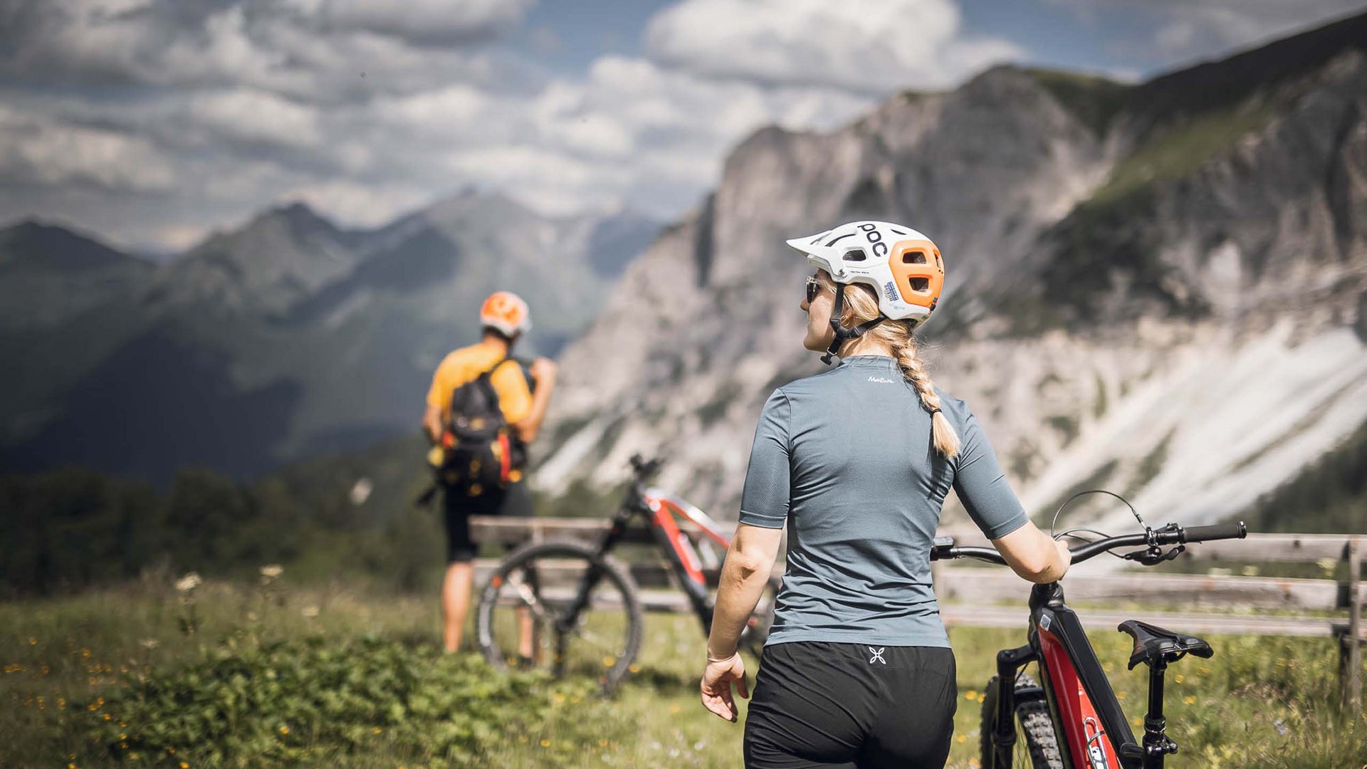 Zwei Radfahrer mit Helm in den Bergen bei sonnigem Wetter