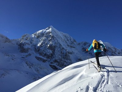 A Ladurns, c’è l’hotel perfetto per le vacanze invernali Scialpinista in salita su montagna innevata con cielo blu limpido