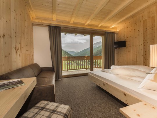 Family hotel in Sterzing: hoi, hello, and welcome! Cozy wooden room with balcony and mountain view