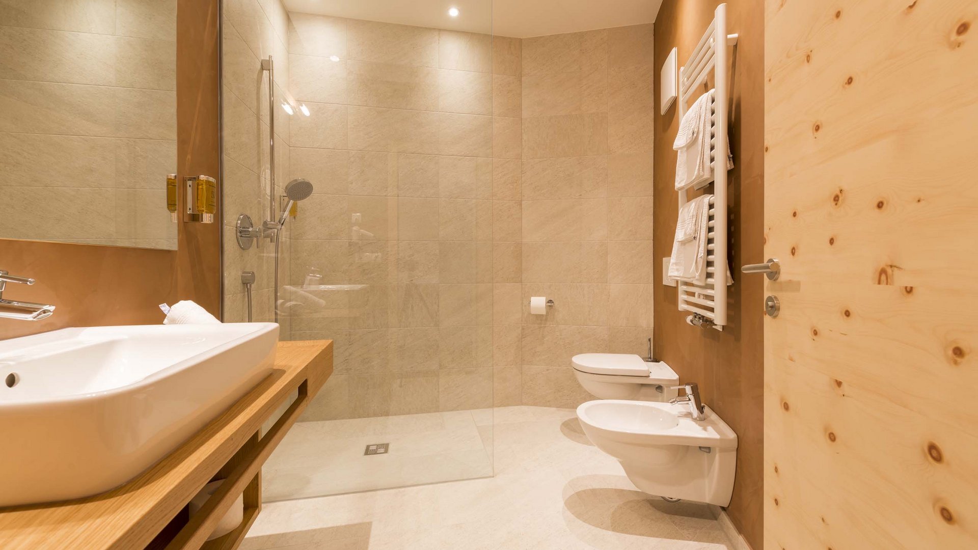 Hotel in Pflerschtal: rooms and offers Modern bathroom with light wood and beige tiled shower
