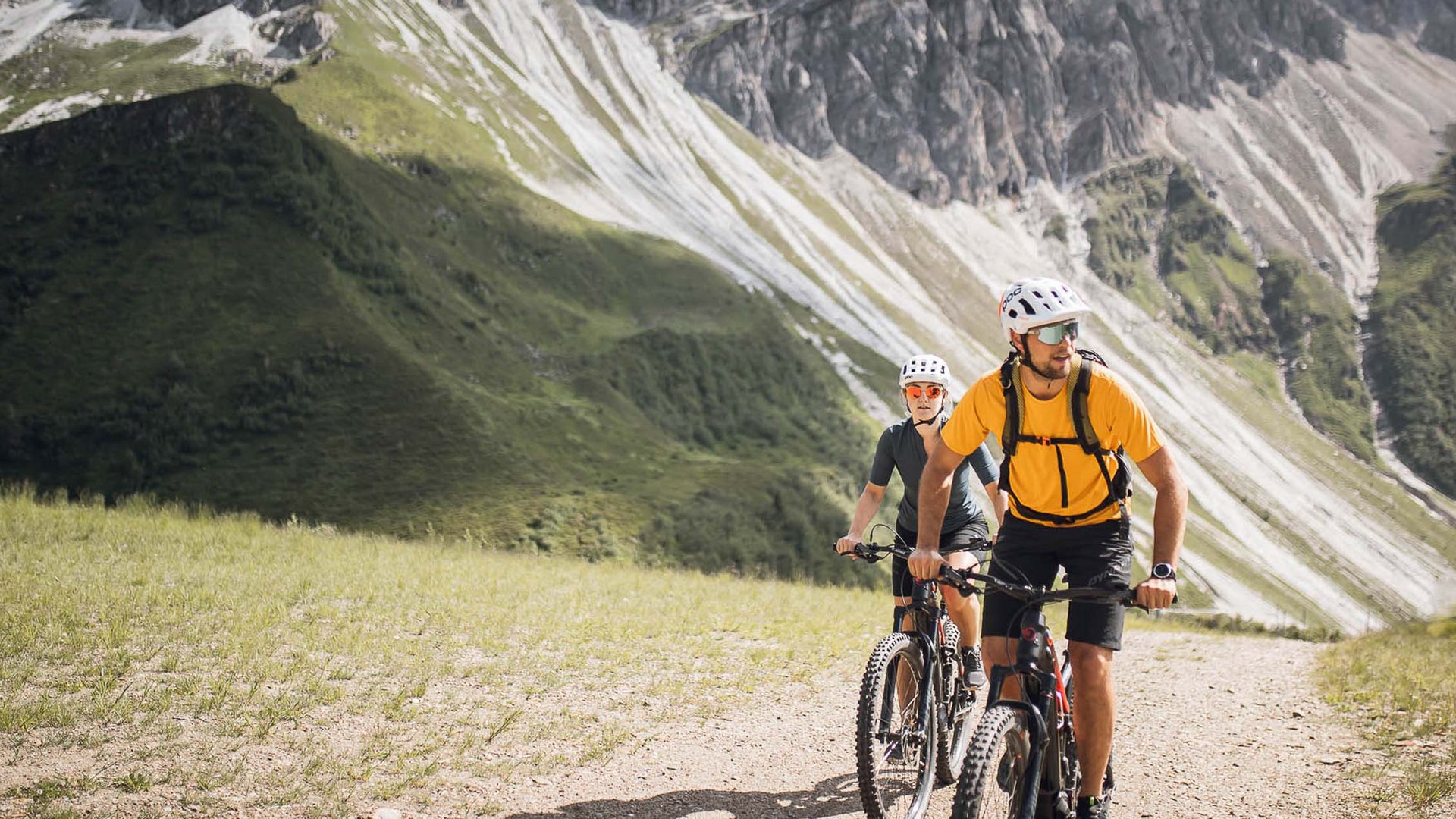 Aktivhotel in Südtirol: Sommererlebnisse Zwei Mountainbiker fahren auf einem Bergweg unter zerklüfteten Gipfeln