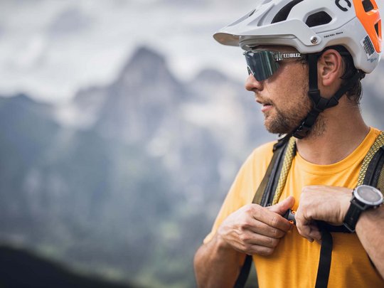 Lo sport a Colle Isarco vi coinvolgerà Uomo con casco e zaino davanti a paesaggio montano